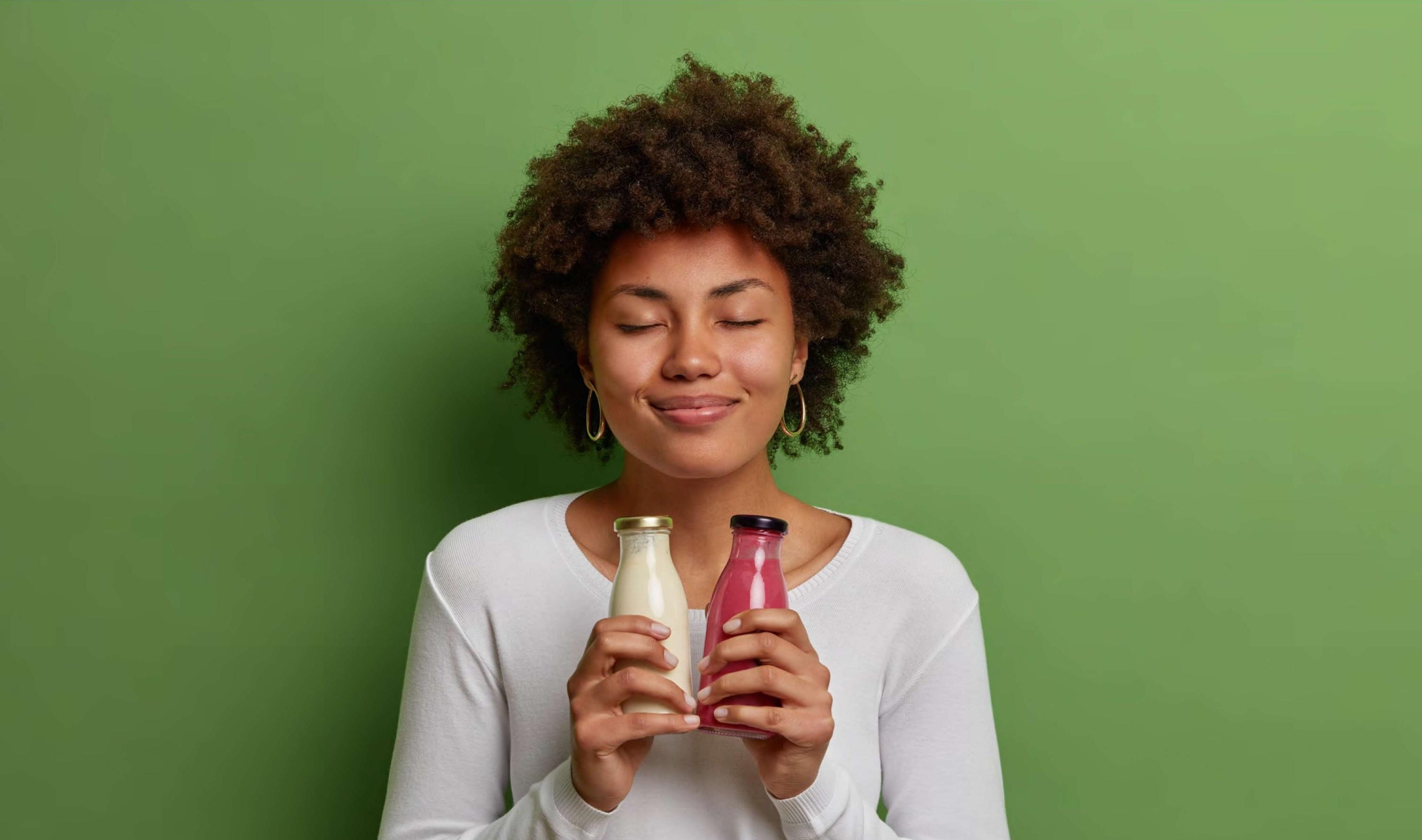 A young woman holding two Sipora bottles